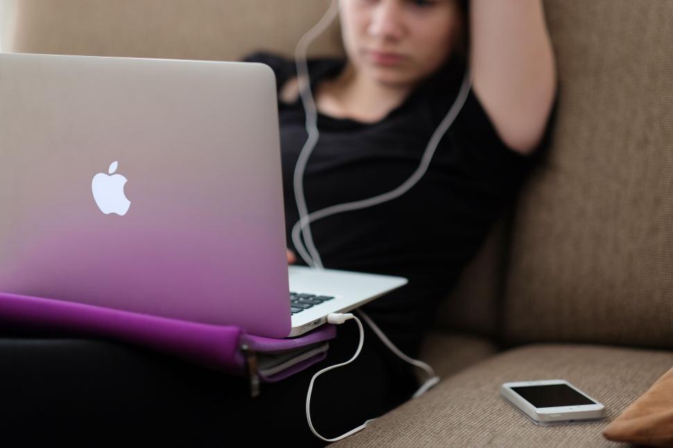 Free Image of Person relaxing with laptop and smartphone on couch 