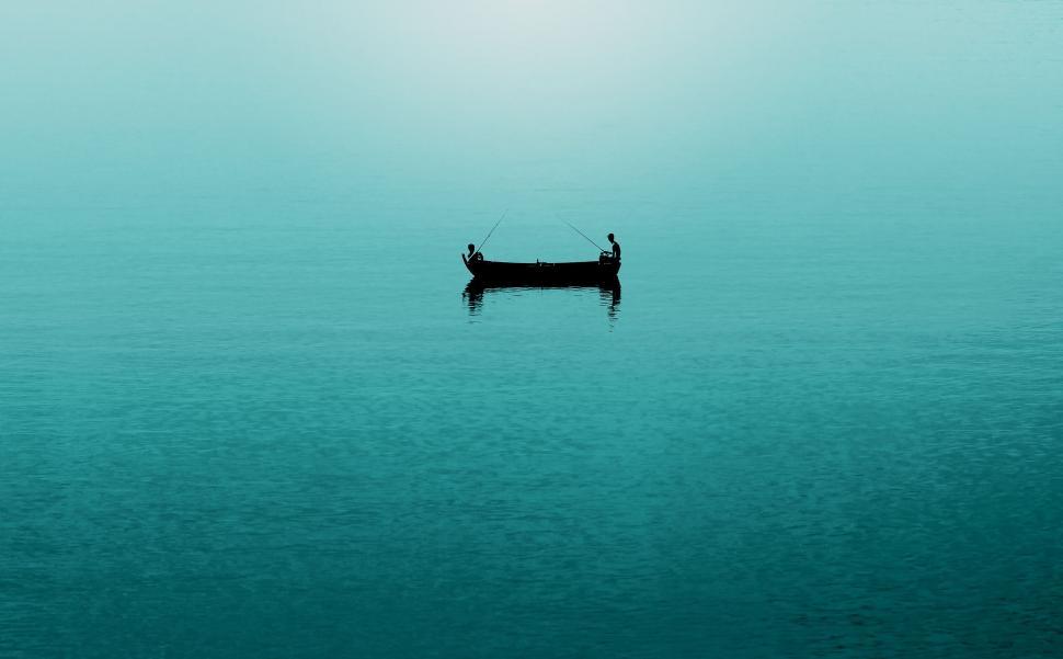 Free Image of Two people fishing on a boat in a serene blue lake. 