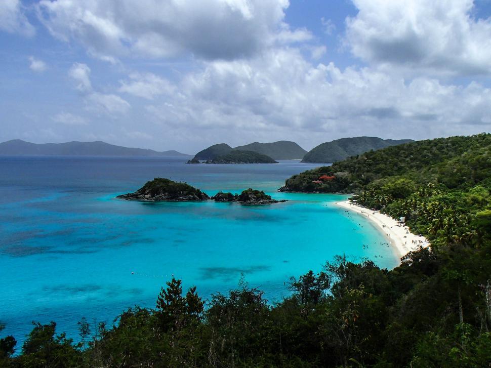 Free Image of Scenic beach with turquoise waters and lush island views 