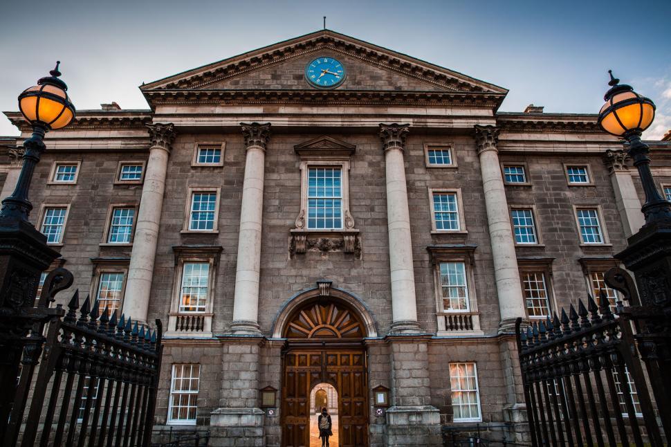 Free Image of Historical building facade with pillars and clock on top. 
