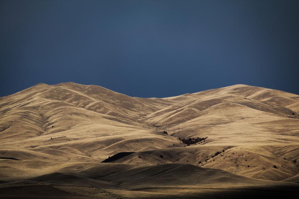 Free Image of Expansive desert landscape under a dramatic dark sky. 