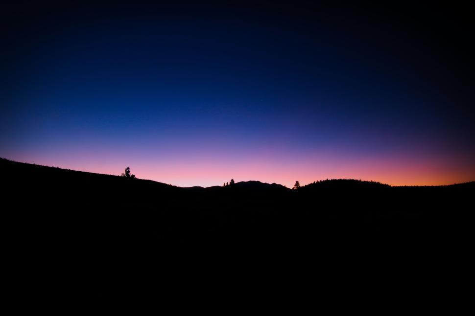 Free Image of Silhouetted landscape at dusk with colorful sky gradient. 