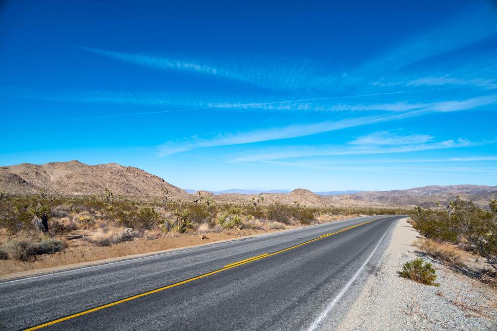 Free Image of Desert highway stretching into the bright blue sky 