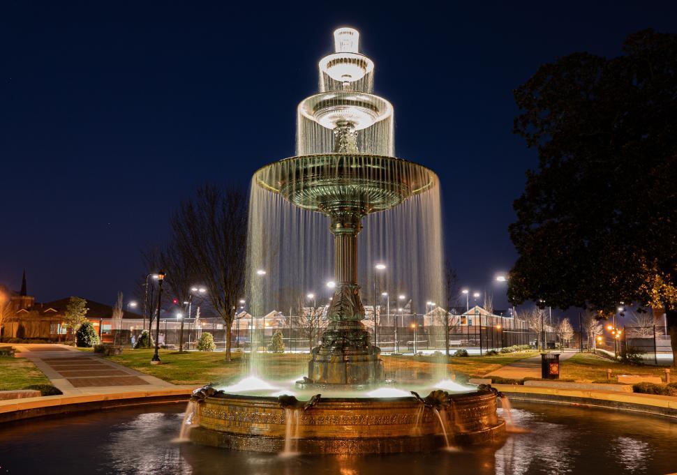 Free Image of Illuminated fountain at night with bright lights around 