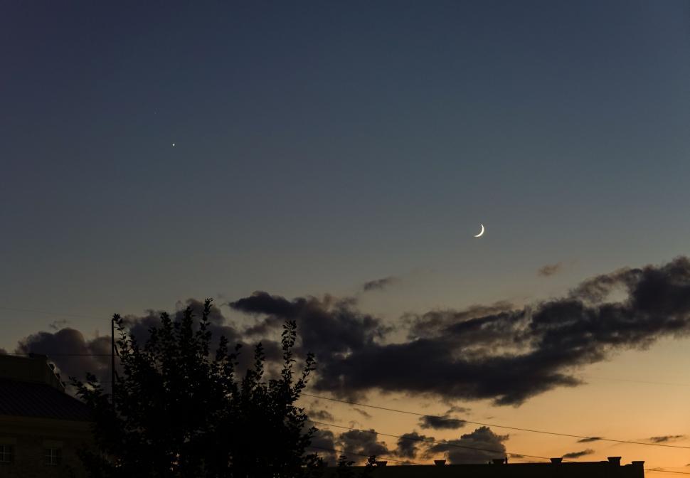 Free Image of Twilight sky with crescent moon and scattered clouds. 