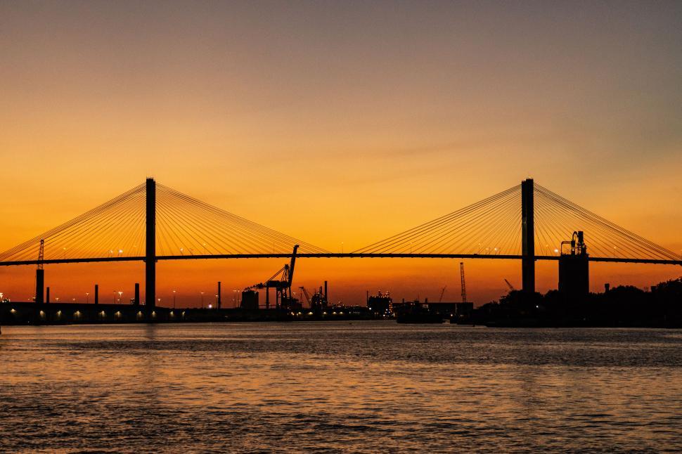 Free Image of Golden sunset behind silhouette of a grand bridge. 