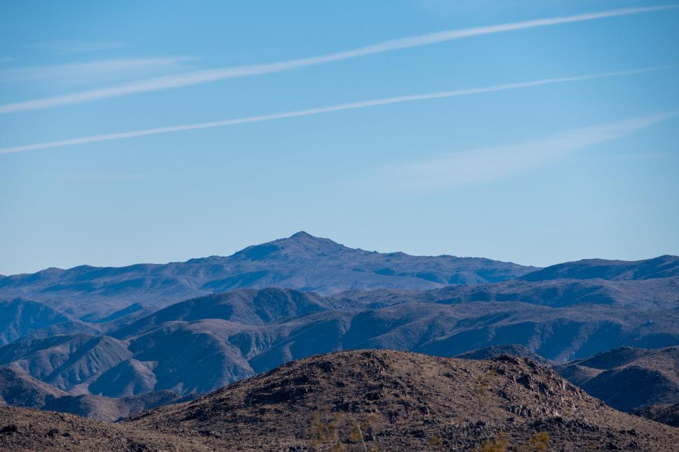 Free Image of Mountainous terrain under a sunny clear blue sky 