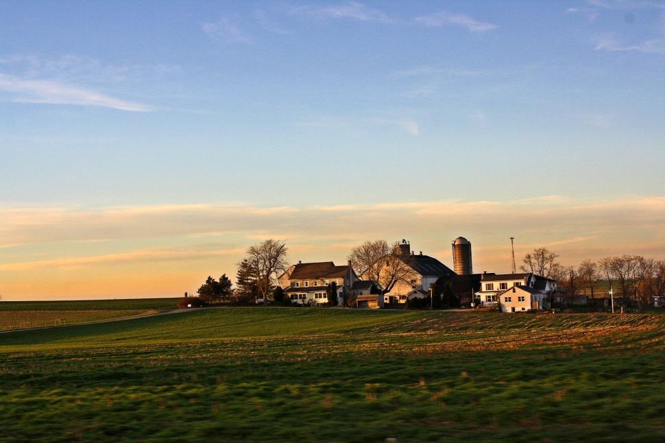 Free Image of Panoramic view of a farm at sunset with clear sky 