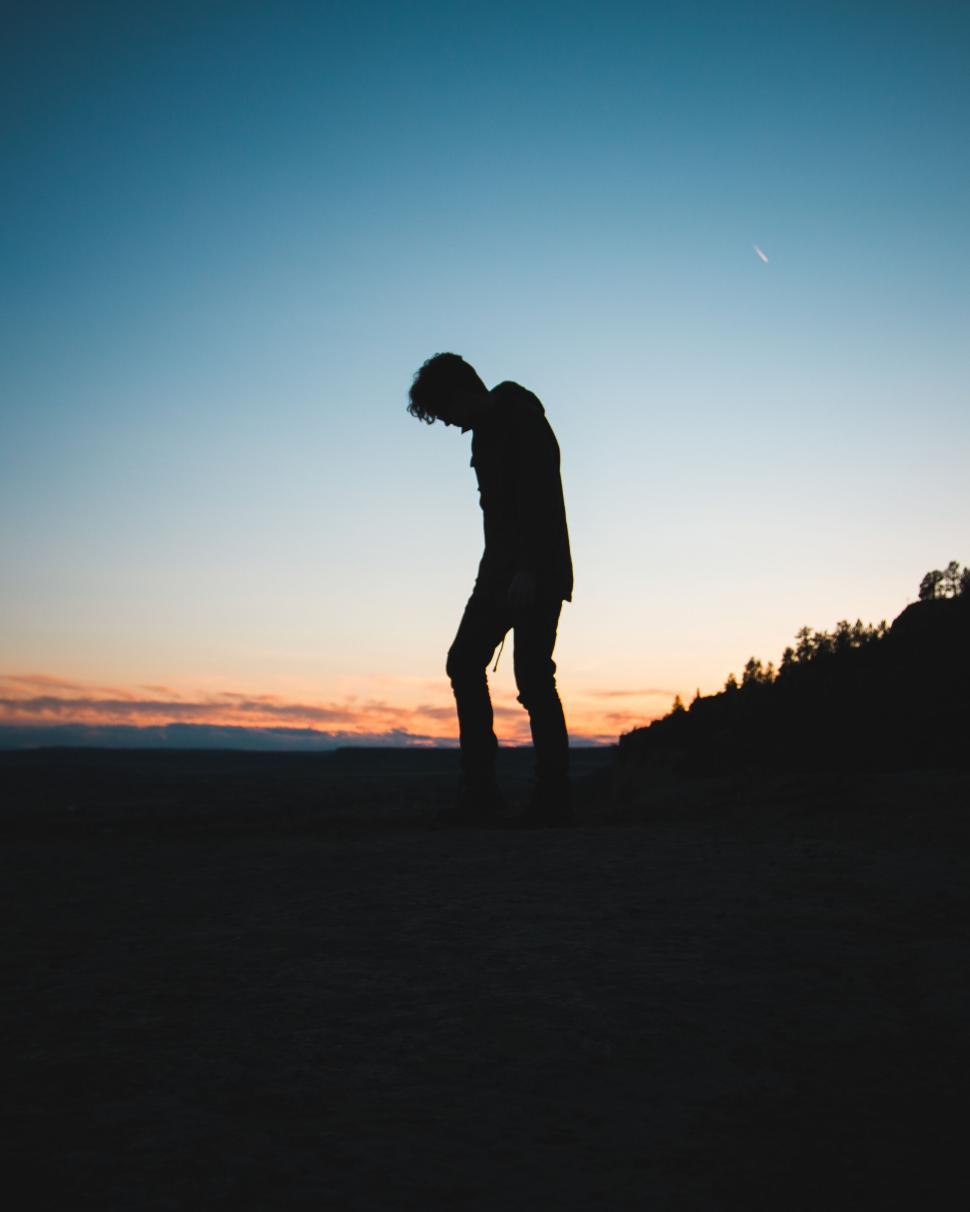 Free Image of Person Standing Silhouetted Against Colorful Sunset Sky 