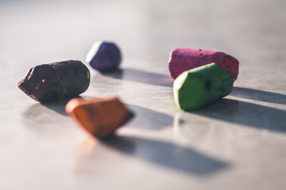 Free Image of Colorful, scattered chalks casting shadows on a surface. 