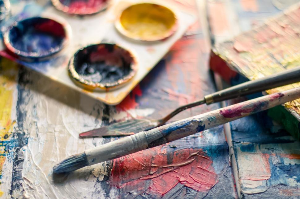Free Image of Artist s workspace with vibrant paint and brushes. 