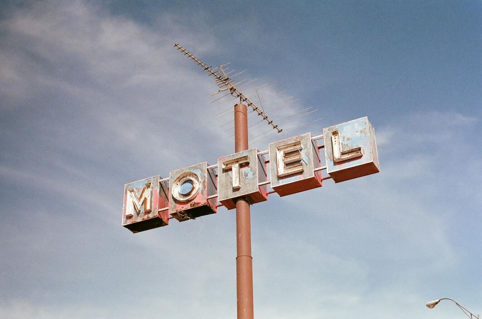 Free Image of Vintage motel sign against a blue sky backdrop 