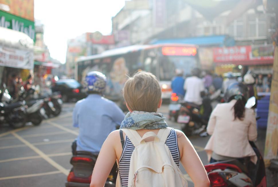 Free Image of Back view of a woman in a busy urban setting 