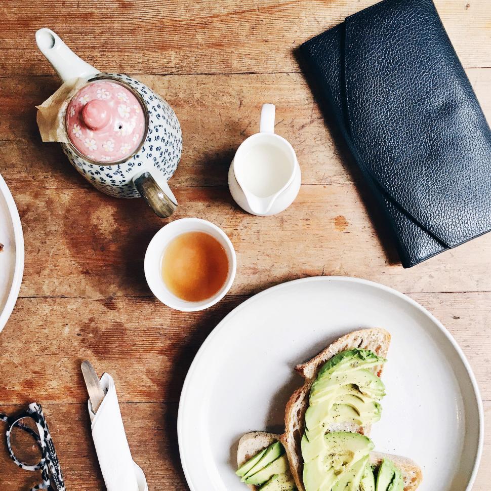 Free Image of Breakfast with avocado toast, tea set, and accessories on table 