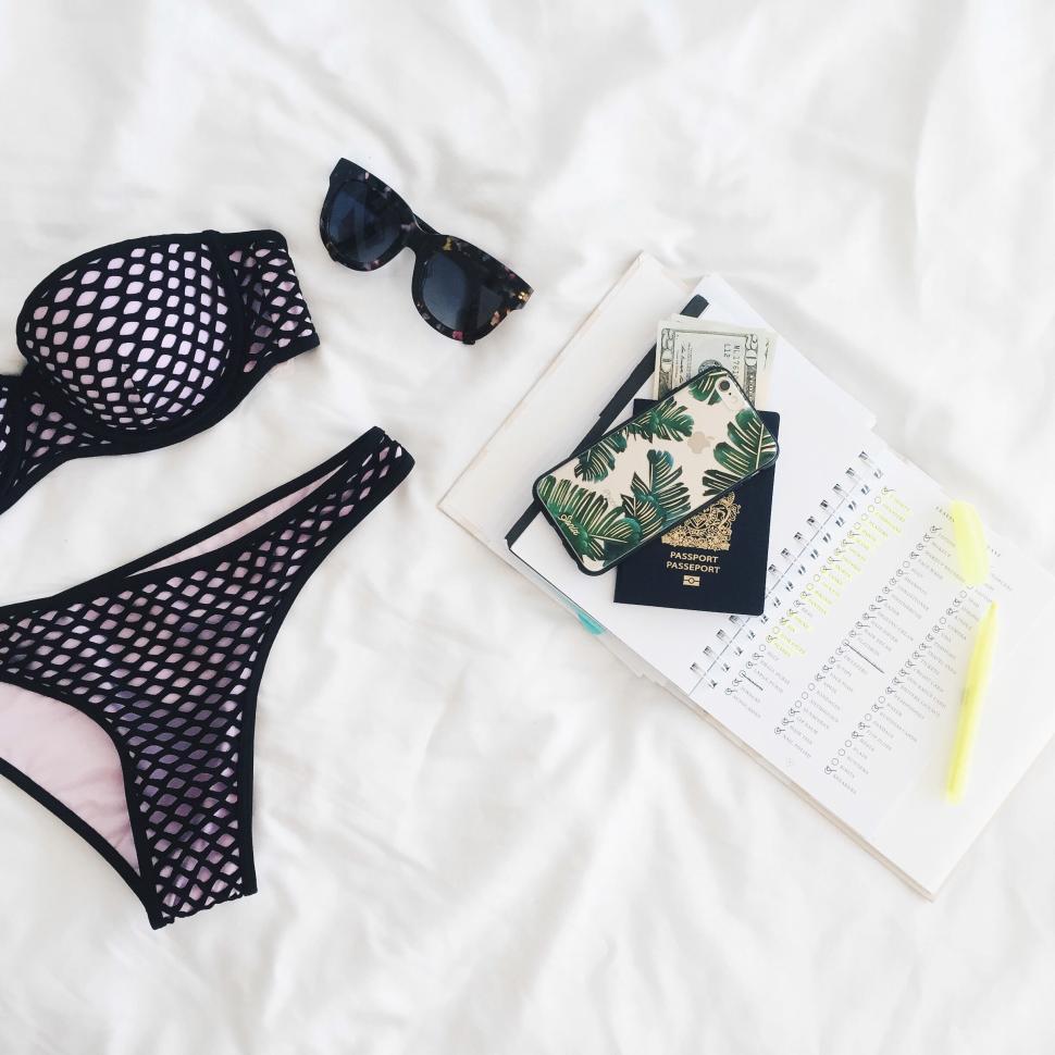 Free Image of Summer essentials for a trip, flatlay on bed. 