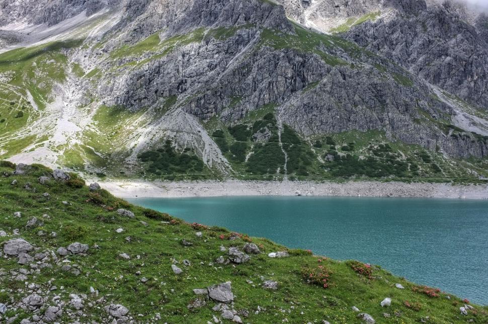 Free Image of Turquoise alpine lake surrounded by rocky mountain terrain 