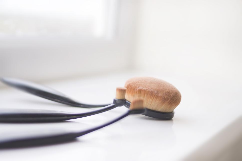 Free Image of Makeup brushes resting on a white windowsill 
