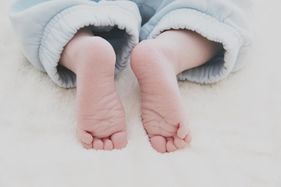 Free Image of Close-up of baby s feet dressed in soft blue pants. 