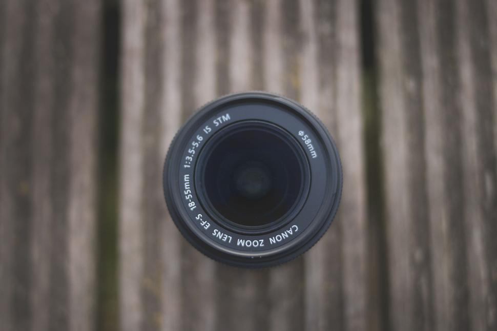 Free Image of Lens facing down on a wooden surface, top view shot 
