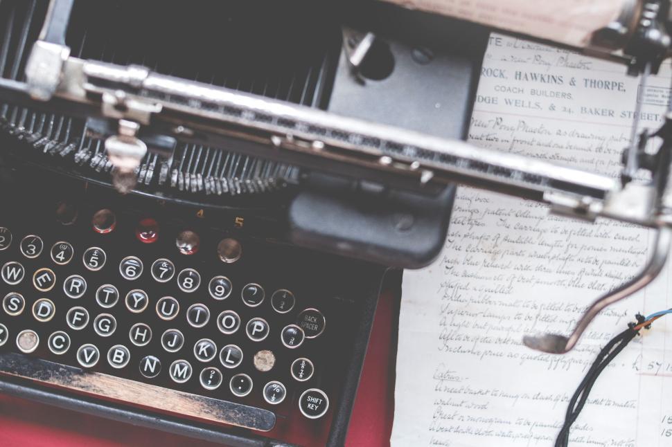 Free Image of Old typewriter with paper, some text handwritten beside it 