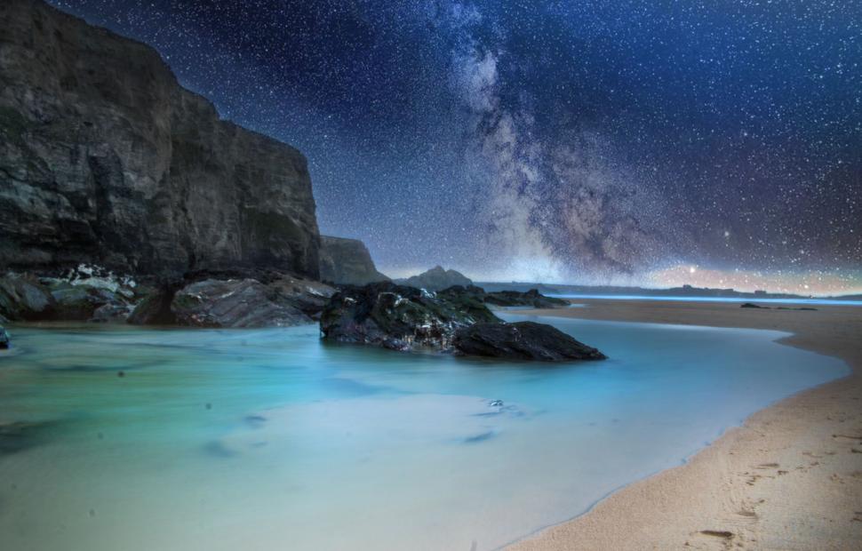 Free Image of Night view of rocky beach under a starry sky with galaxy 