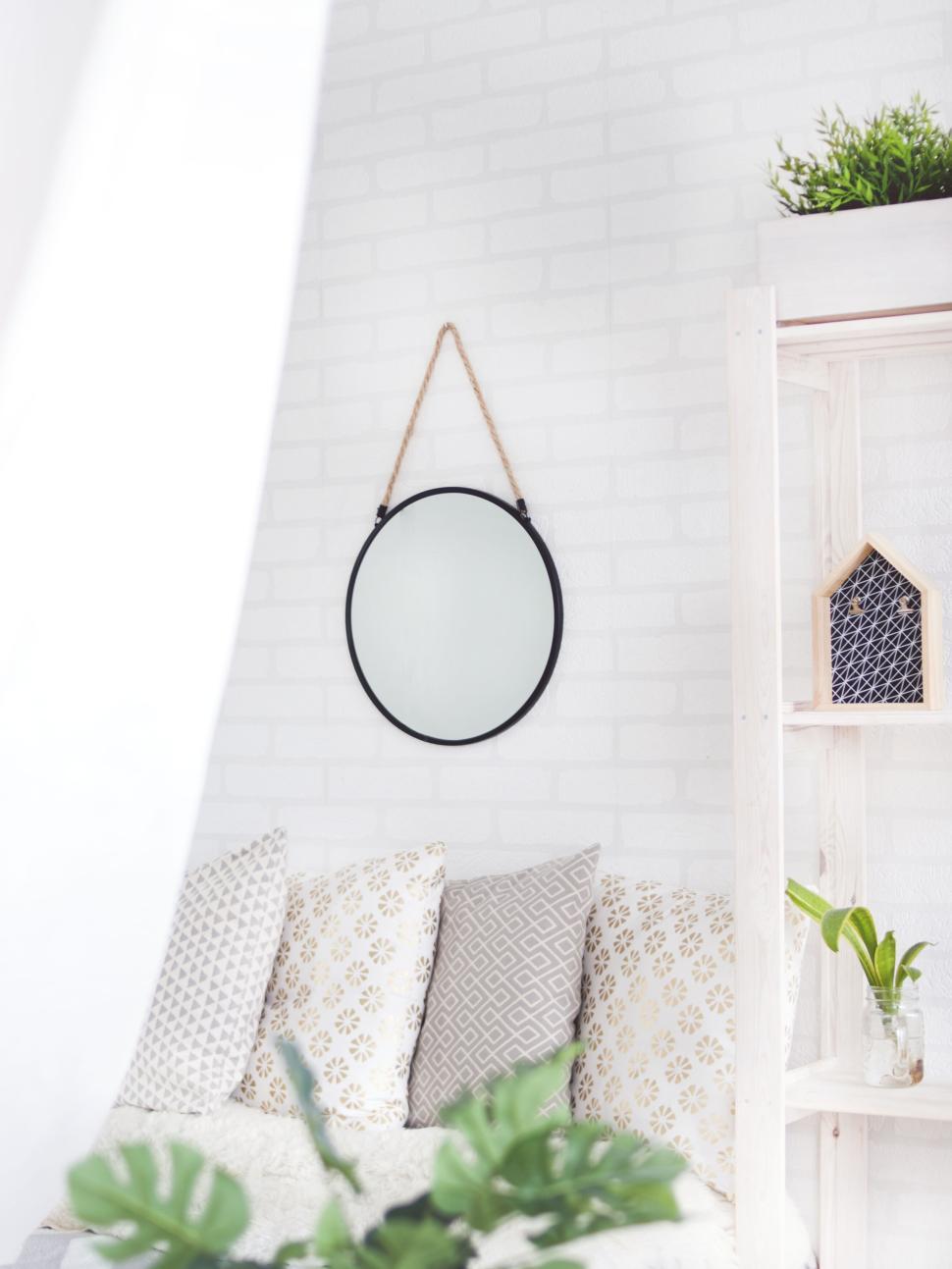 Free Image of Minimalistic interior with decor and round hanging mirror. 
