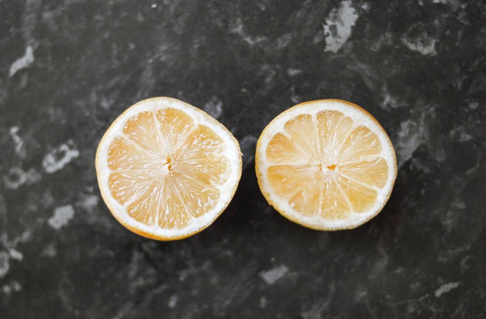 Free Image of Halved lemons on dark marble kitchen countertop 