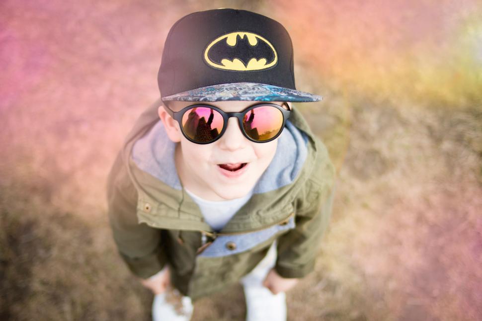 Free Image of Kid with Batman cap looking upwards in the park 