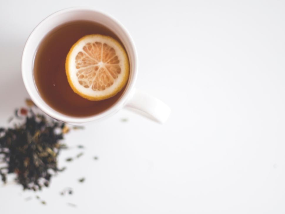 Free Image of Cup of tea with lemon slice and loose leaf tea beside 