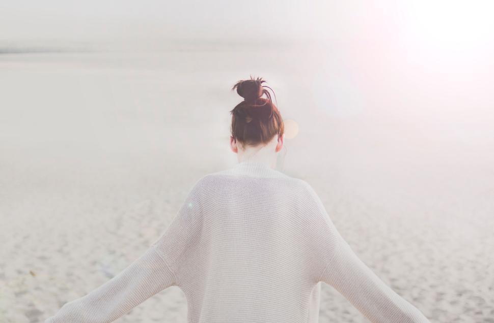 Free Image of Woman facing away from camera, on deserted beach 