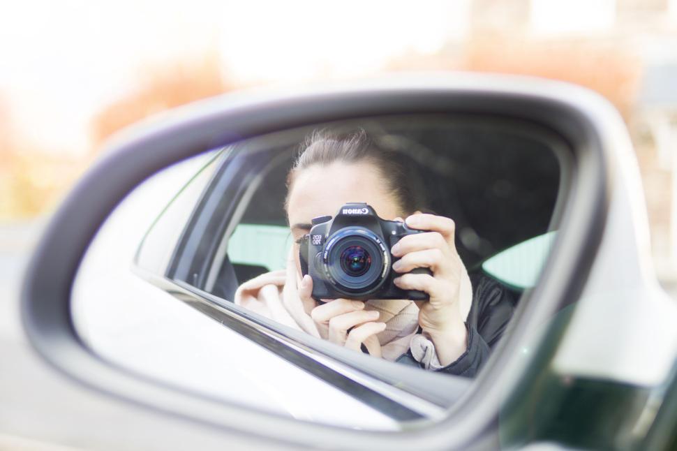 Free Image of Reflection of a photographer in a car s rear view mirror. 