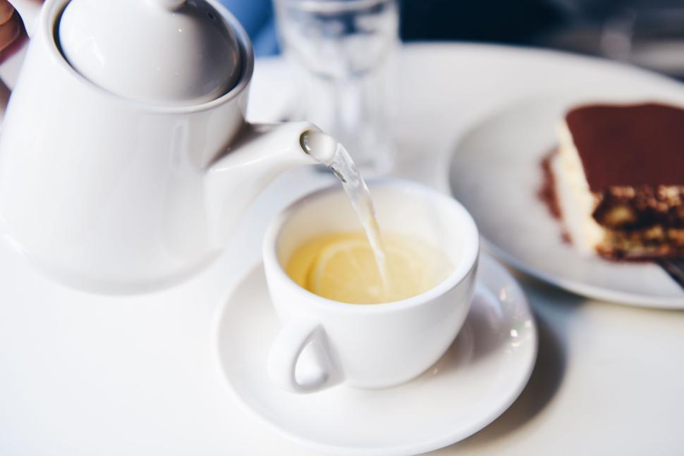 Free Image of Pouring tea into a cup with a slice of lemon inside. 