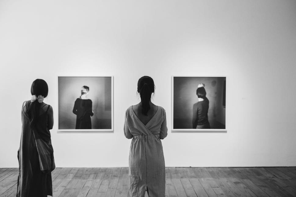 Free Image of Two women exploring black and white art in gallery. 