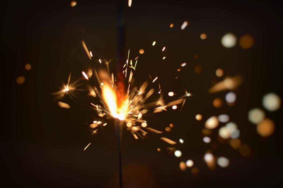 Free Image of Sparkler burning with bright tiny sparks in the dark 