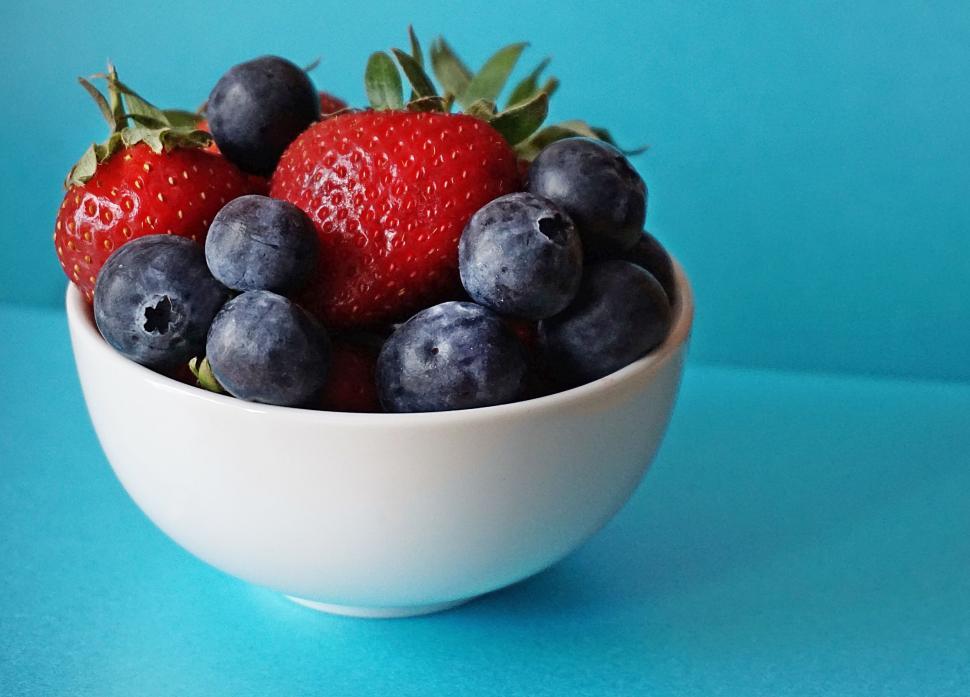 Free Image of Fresh strawberries and blueberries in a white bowl. 