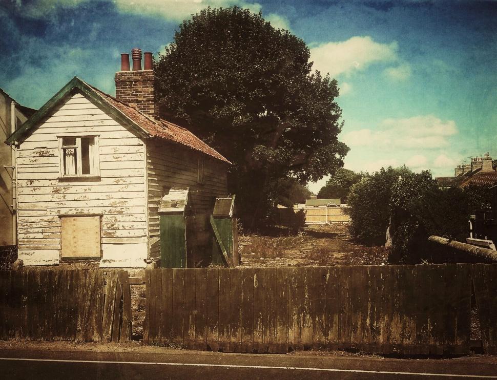 Free Image of Old rustic house with peeling paint and large tree. 