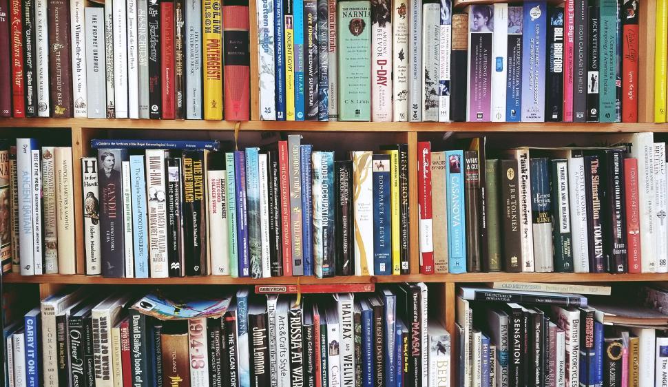 Free Image of Bookshelf filled with assorted books in various genres. 