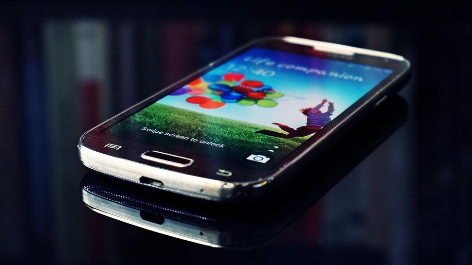 Free Image of Smartphone lying on a reflective surface unlocked screen. 