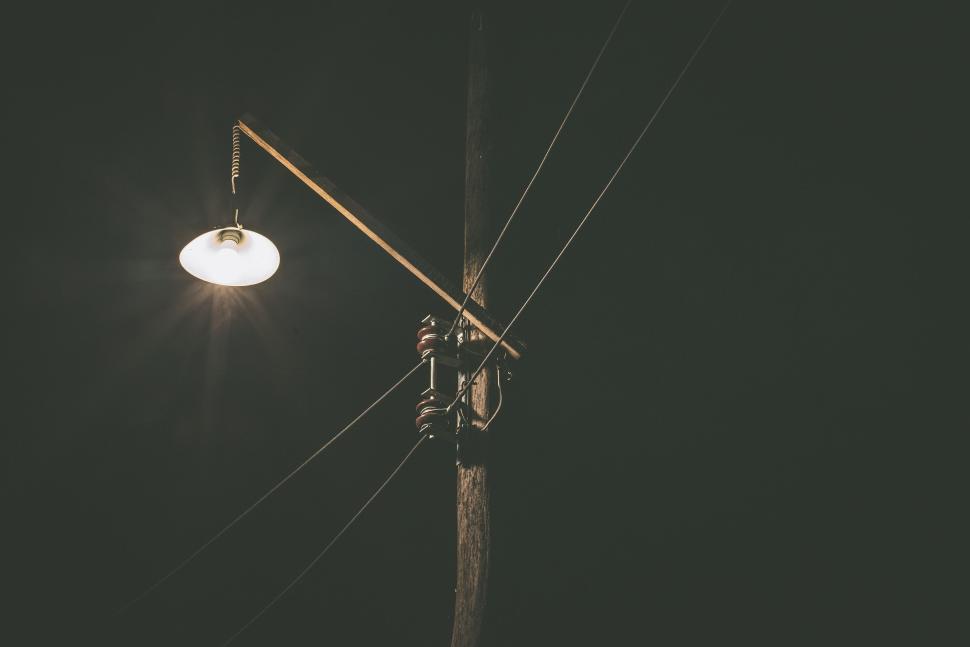 Free Image of Single light fixture on a wooden pole at night. 
