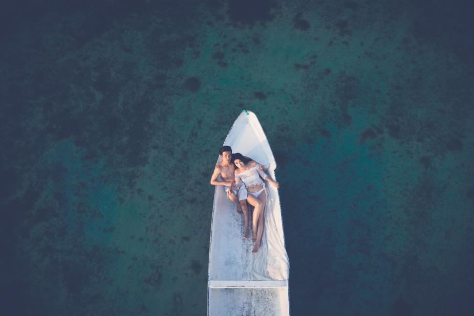 Free Image of Couple relaxing on a boat in clear blue waters. 