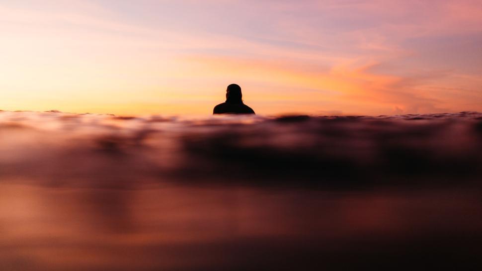 Free Image of Silhouette of person in water during sunset. 