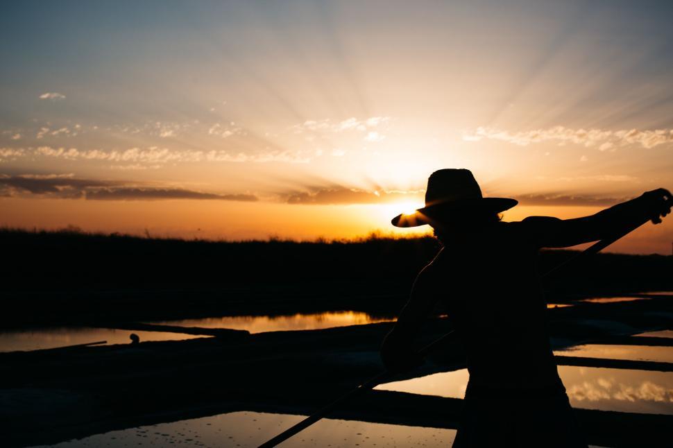 Free Image of Silhouette of fisherman rowing boat at golden sunset 