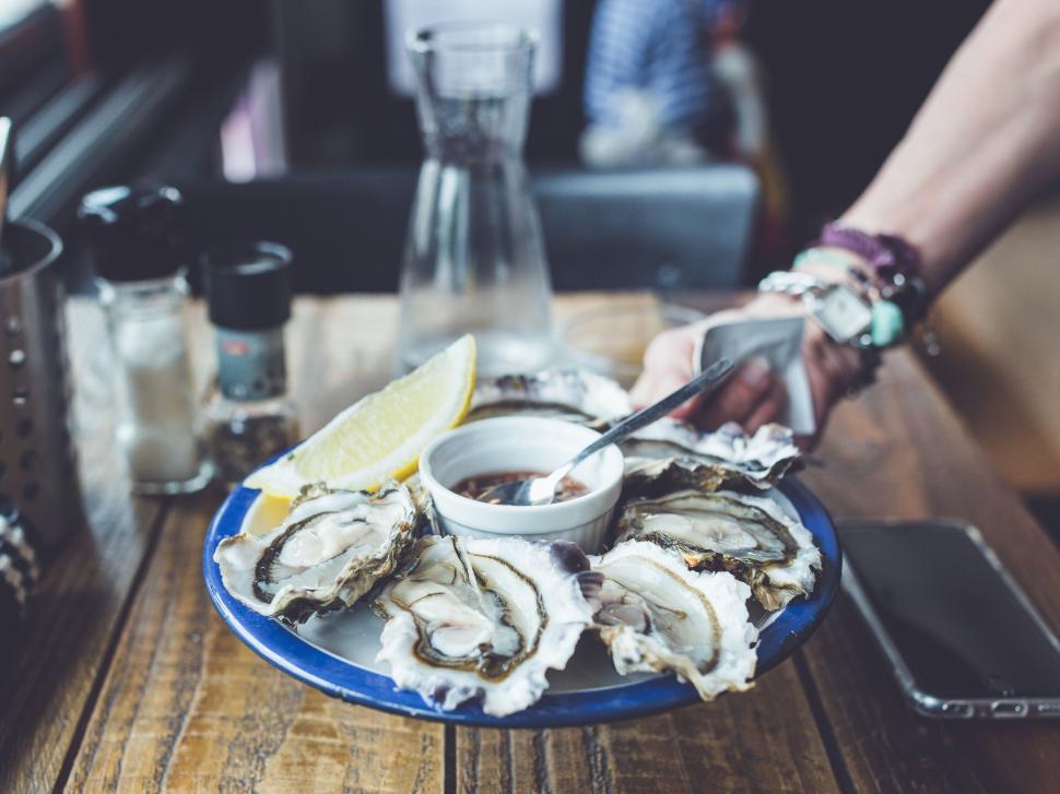 Free Image of Plate of fresh oysters with lemon wedge and sauce 