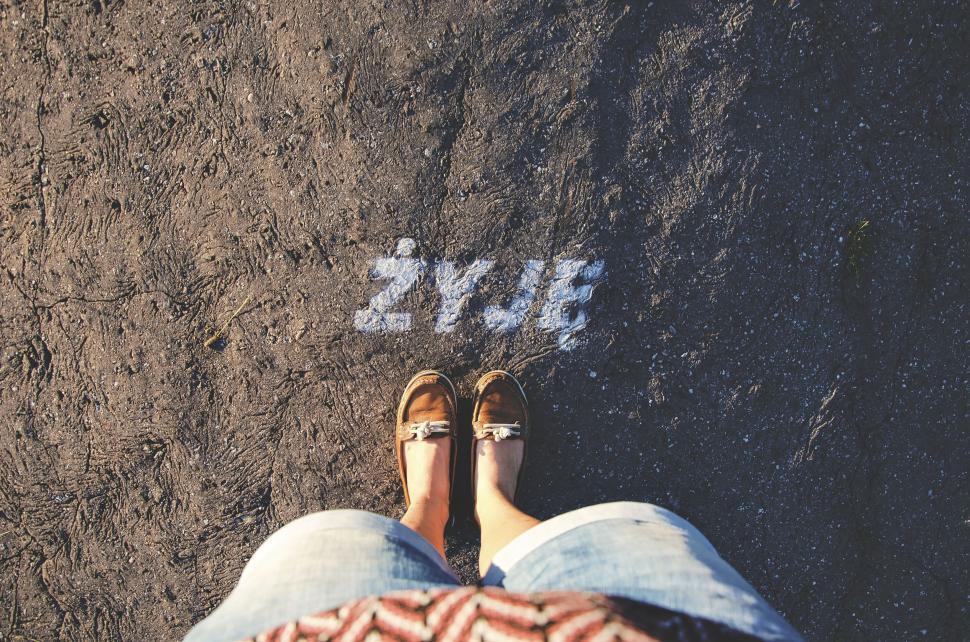 Free Image of Feet on a paved ground with text  ?YJ  spray painted 