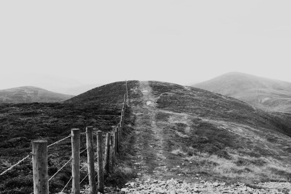 Free Image of Grassy pathway leading to a hill s peak in the distance. 