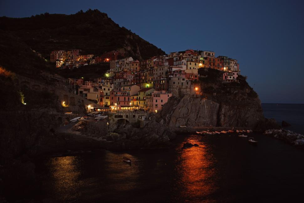 Free Image of Scenic coastal town lit up under the night sky. 