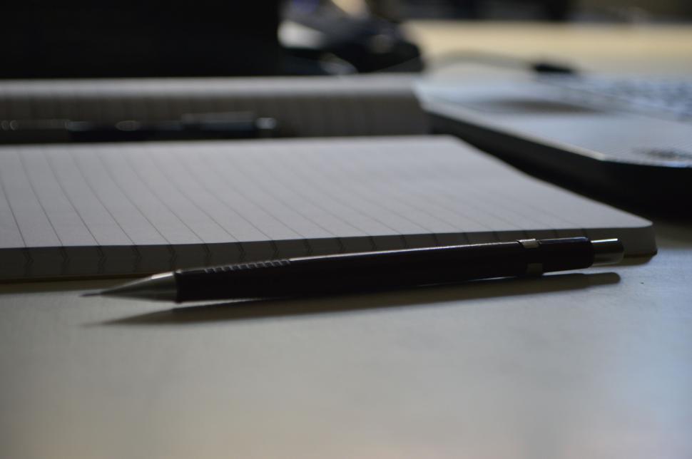 Free Image of Spotlight on pencil resting over lined open notebook 
