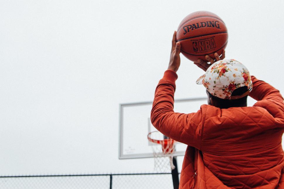 Free Image of Person taking a basketball shot at outdoor court 