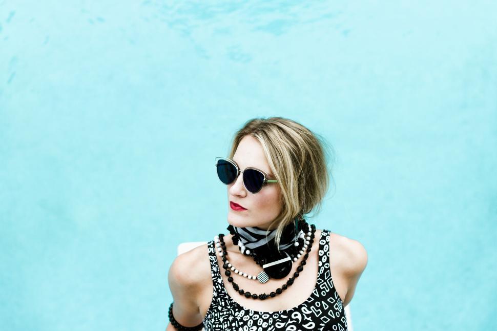 Free Image of Stylish woman posing against a turquoise background 