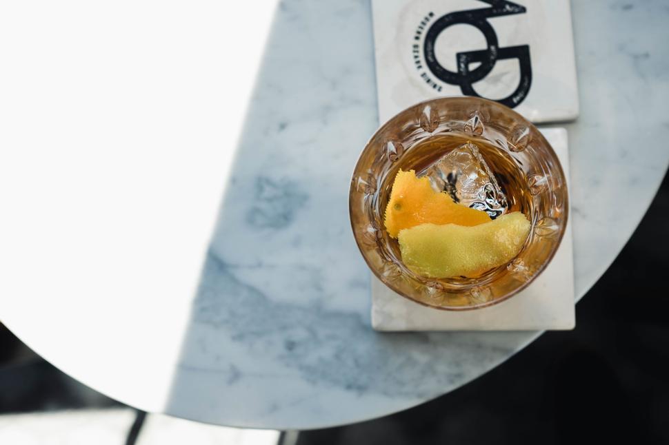 Free Image of A cocktail with twist of citrus on marble table 
